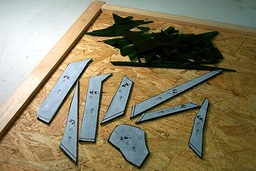 Front: cut glass pieces awaiting edge grinding; rear: the scrap glass it took to produce those eight nice cuts.