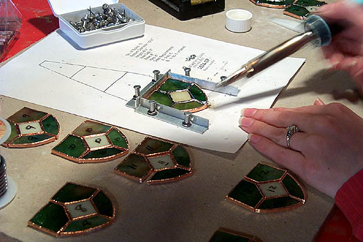 Soldering lamp pieces.