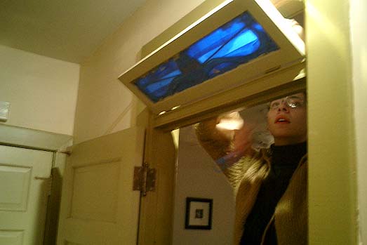 The transom mounted by its hinges and metal arms, I get the honor of pulling the painters' tape from the glass.