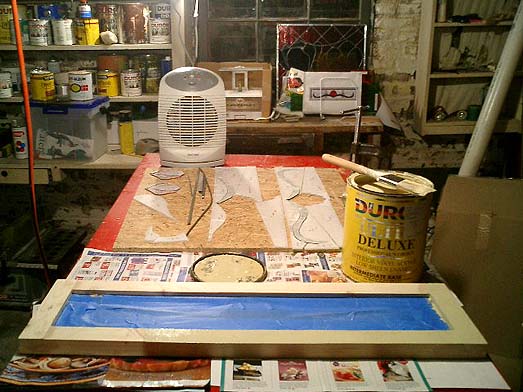 Transom number one, having its frame painted. Dig my workshop---excuse me, our workshop---the grinder, the toolbox, full-color 'artist's renderings' of the transoms, the crocus panel, the all-important space heater.